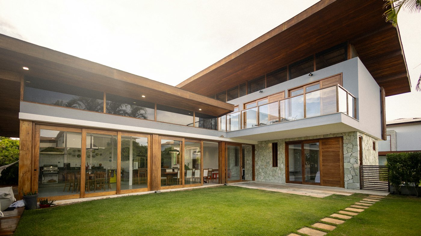 Modern house with floor-to-ceiling windows and a green lawn