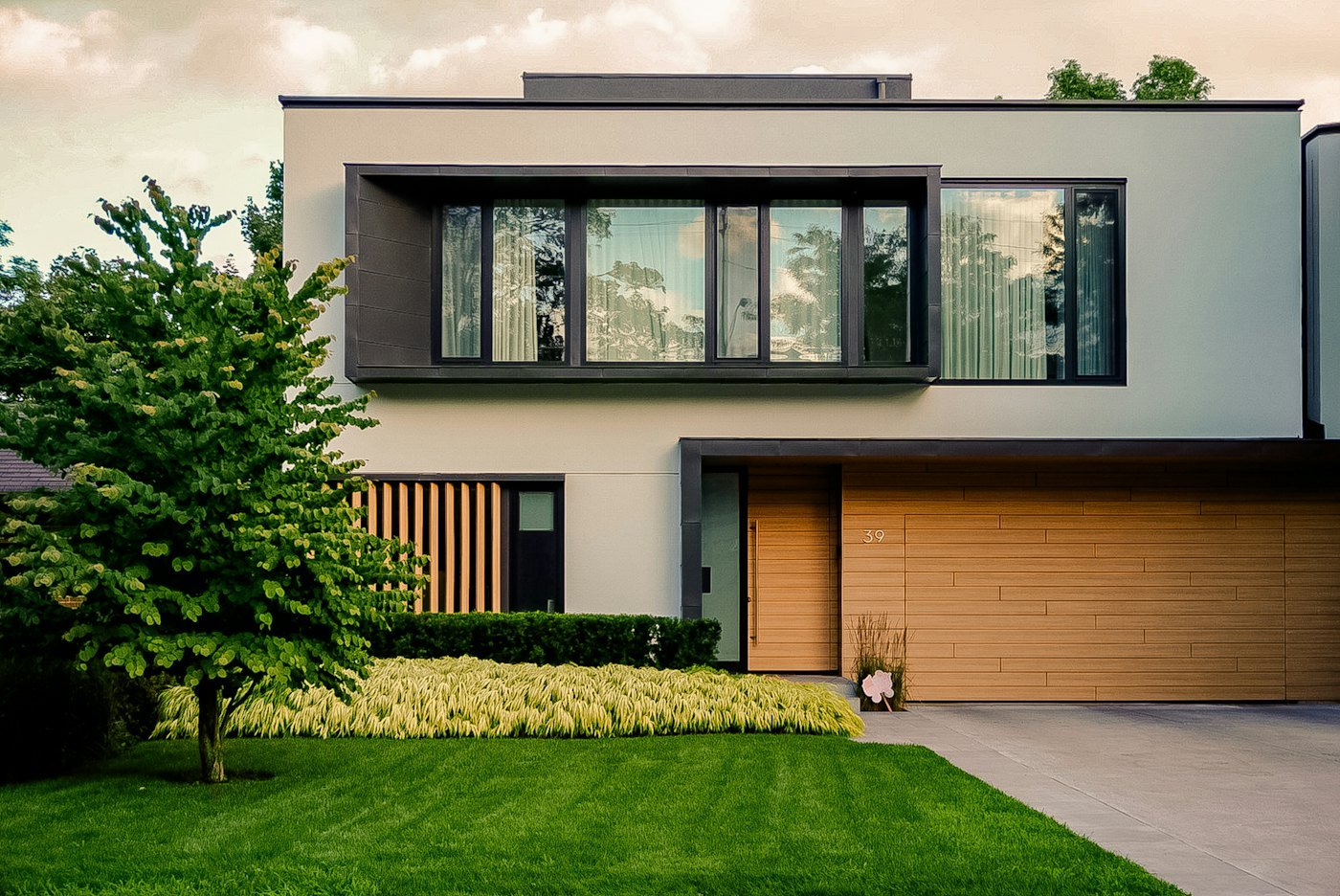 Two-storey suburban home with a tree and a green front lawn