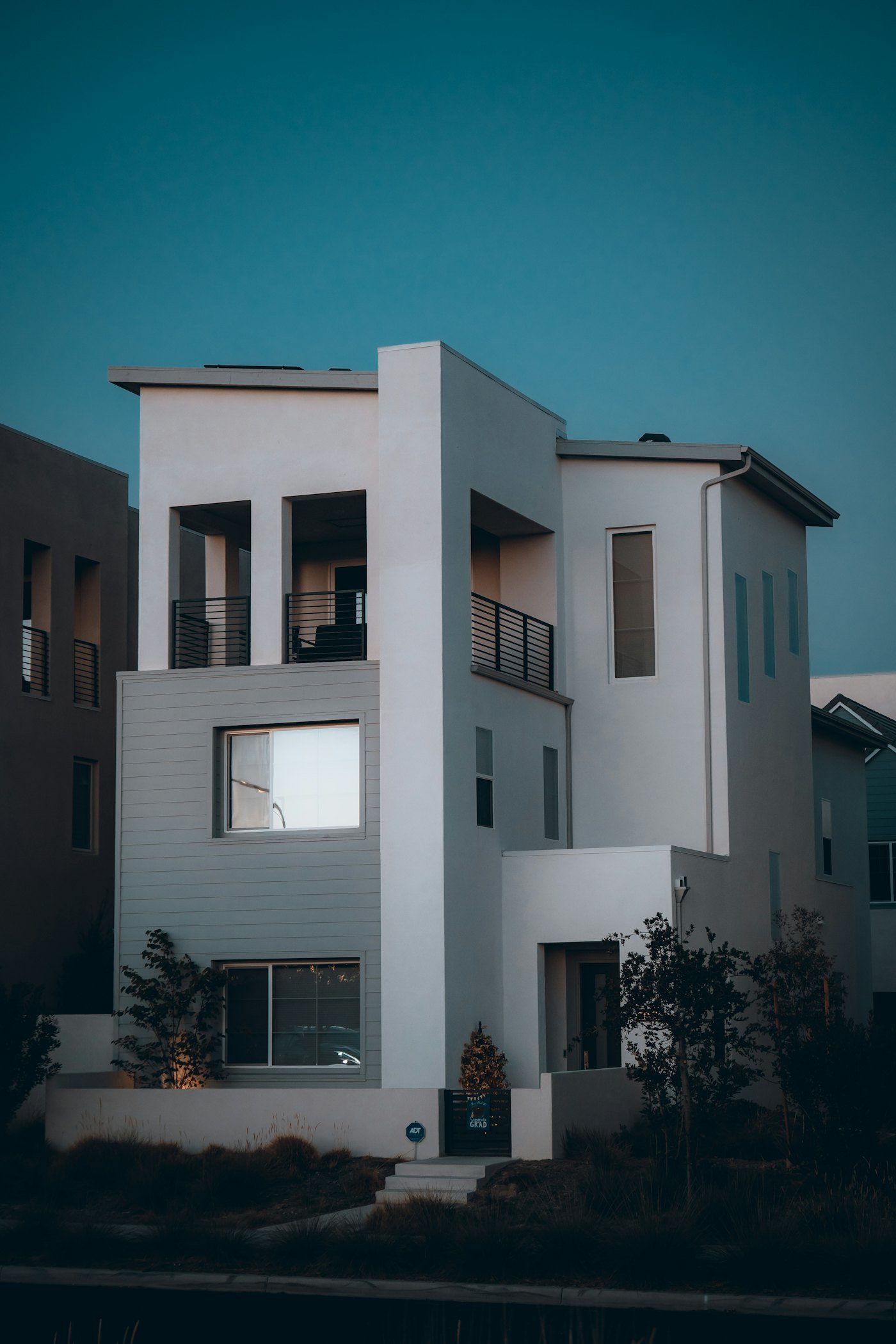 Modern white three-story house at dusk