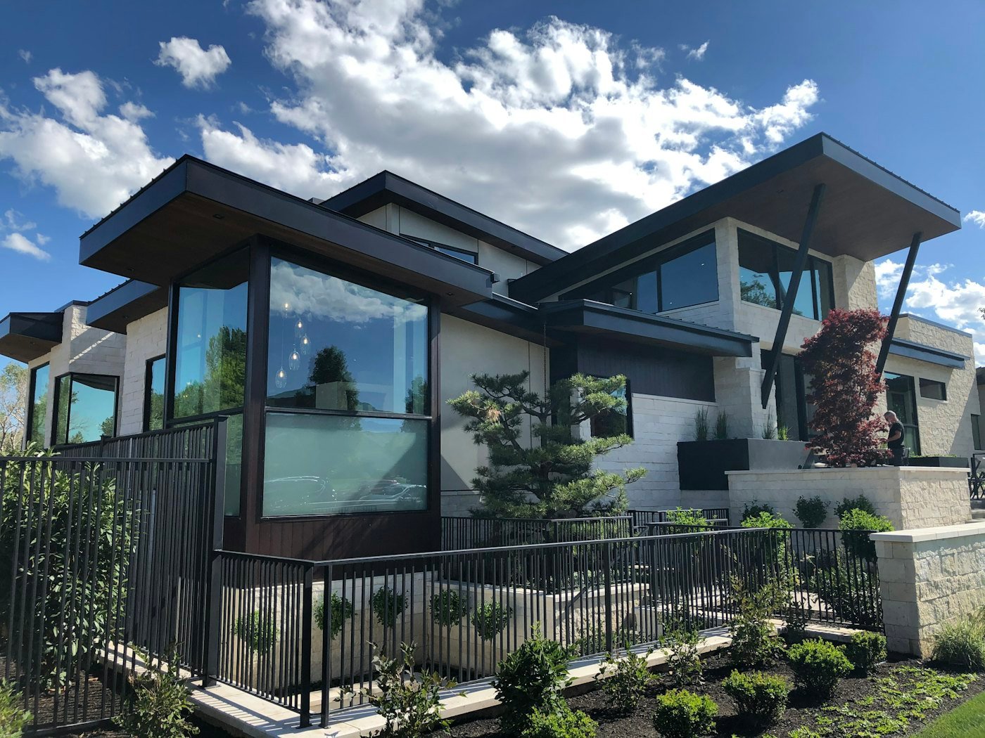 Modern two-story home with large windows under a blue sky